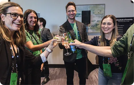 Attendees toasting with drinks at Be Herd 2026